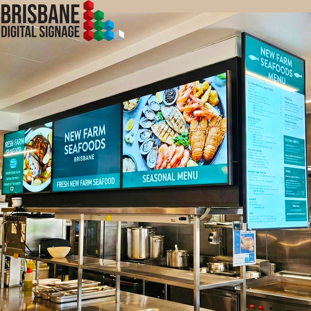 Commercial kitchen featuring landscape and vertical digital menu boards at New Farm Seafoods Brisbane showing high definition food images.